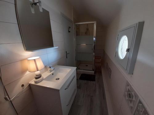 une salle de bain blanche avec un lavabo et un miroir dans l'établissement Studio cosy avec Wi-Fi à 50m du centre, proche des Thermes - La Roche-Posay - FR-1-541-56, à La Roche-Posay