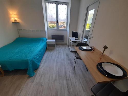 une chambre avec un lit et un bureau avec un ordinateur dans l'établissement Studio cosy avec Wi-Fi à 50m du centre, proche des Thermes - La Roche-Posay - FR-1-541-56, à La Roche-Posay