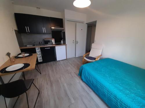 une chambre avec un lit et un bureau et une cuisine dans l'établissement Studio cosy avec Wi-Fi à 50m du centre, proche des Thermes - La Roche-Posay - FR-1-541-56, à La Roche-Posay