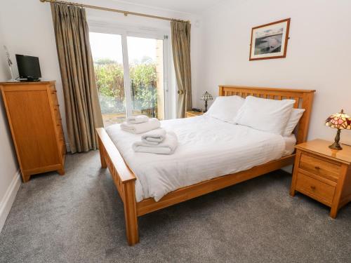 a bedroom with a bed with towels on it at 9 Porth Veor Villas in Saint Columb Minor