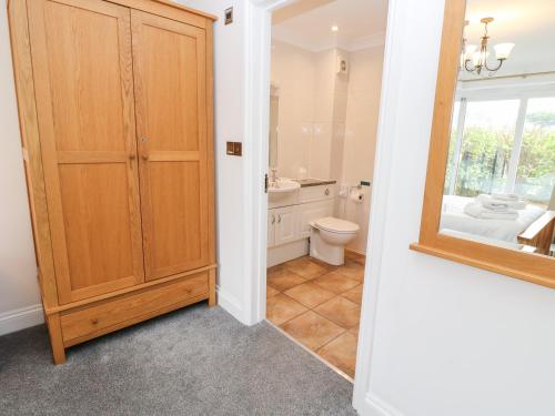a bathroom with a toilet and a sink and a mirror at 9 Porth Veor Villas in Saint Columb Minor