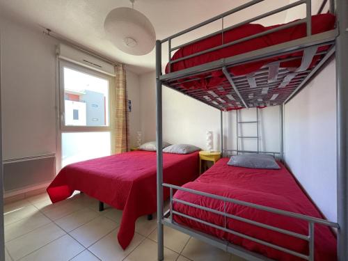 two bunk beds in a room with a window at Appartement 2P avec piscine, proche plage et commerces, parking inclus - Sète - FR-1-338-5 in Sète