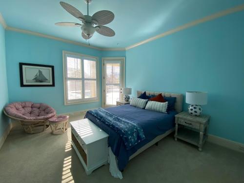 a blue bedroom with a bed and a ceiling fan at Vacation Retreat with Pool, Gym, Kitchen in Sugar Hill