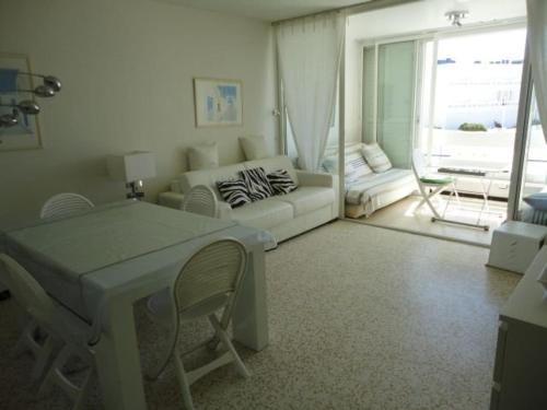 un salon avec un canapé et une table dans l'établissement Appartement 2 pièces avec piscine et parking, en bord de plage - FR-1-250-213, au Grau-du-Roi
