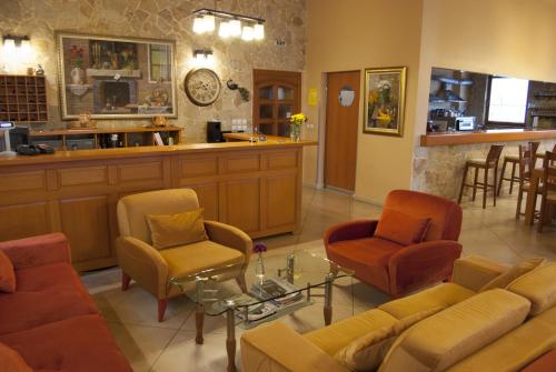 a waiting room with a couch and chairs and a counter at Hotel Portal in Skopje