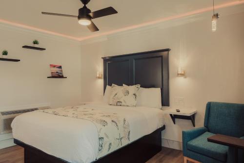 a bedroom with a bed and a blue chair at Blufftop Inn & Suites - Wharf/Restaurant District in Morro Bay