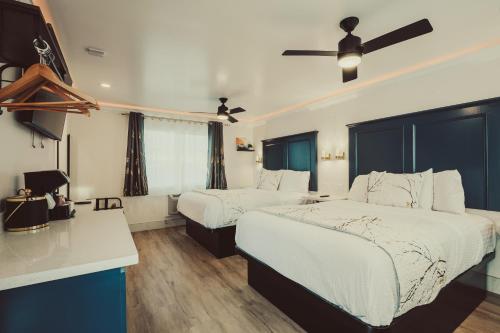 a hotel room with two beds and a desk at Blufftop Inn & Suites - Wharf/Restaurant District in Morro Bay