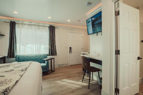 a bedroom with a bed and a desk and a monitor at Blufftop Inn & Suites - Wharf/Restaurant District in Morro Bay
