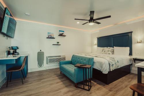 a bedroom with a bed and a blue chair at Blufftop Inn & Suites - Wharf/Restaurant District in Morro Bay