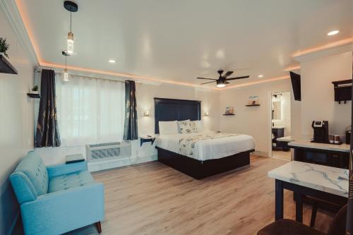 a bedroom with a bed and a couch and a ceiling fan at Blufftop Inn & Suites - Wharf/Restaurant District in Morro Bay