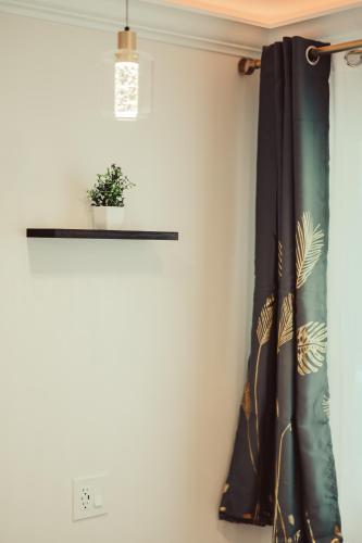 a black curtain in a room with a plant at Blufftop Inn & Suites - Wharf/Restaurant District in Morro Bay