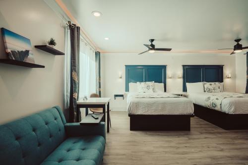 a hotel room with two beds and a couch at Blufftop Inn & Suites - Wharf/Restaurant District in Morro Bay