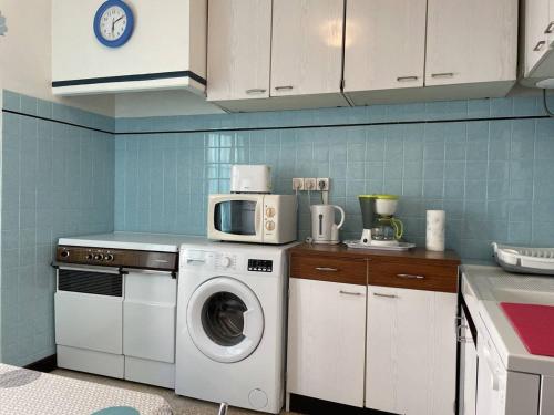 une cuisine avec un lave-linge et un micro-ondes dans l'établissement Appartement 3 pièces, 4 couchages à 100m de la plage, balcon, TV, lave-linge, centre-ville de Banyuls - FR-1-225C-115, à Banyuls-sur-Mer