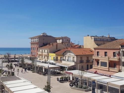 eine Gruppe von Gebäuden in einer Stadt mit dem Meer in der Unterkunft Studio Valras-Plage, 1 pièce, 2 personnes - FR-1-701-57 in Valras-Plage