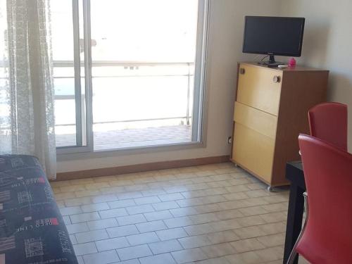 Cette chambre dispose d'une télévision et d'une commode avec une fenêtre. dans l'établissement Studio climatisé, balcon, proche plage et commerces - FR-1-701-57, à Valras-Plage