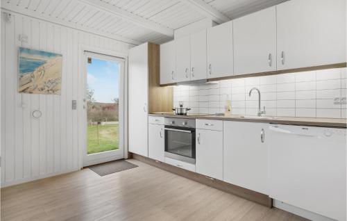 a kitchen with white cabinets and a large window at Stunning Home In Hurup Thy With Wifi in Doverodde