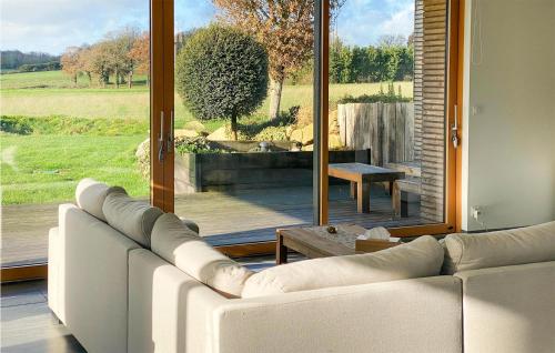 ein Wohnzimmer mit einer weißen Couch und einem großen Fenster in der Unterkunft Stunning Home In Plélan-Le-Petit in Plélan-le-Petit