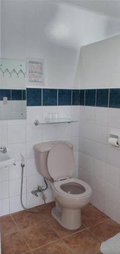 een badkamer met een wit toilet en een wastafel bij SUMMER HOMES BEACH RESORT in Port Barton
