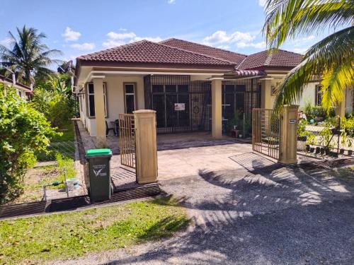 a house with a trash can in front of it at Sacha Permai Homestay in Baling