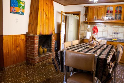 - une cuisine avec une table et une cheminée en briques dans l'établissement Posada La Teresita, à La Consulta