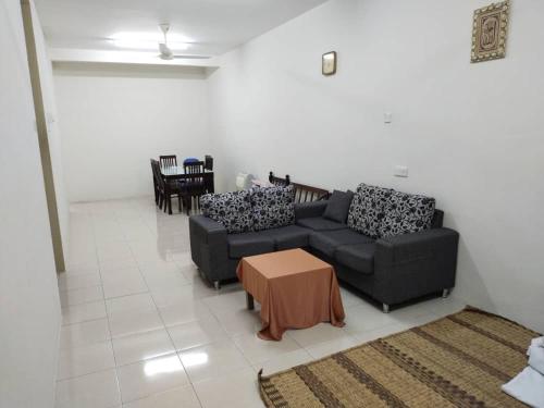 a living room with two couches and a table at Permai Homestay in Baling