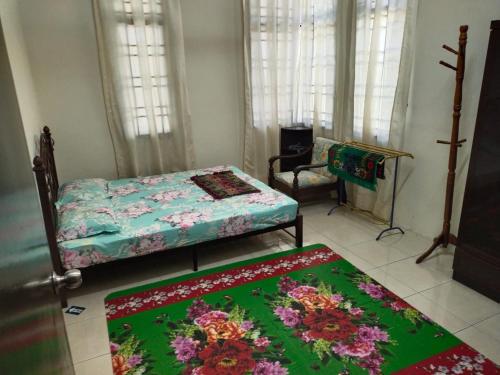 a bedroom with two beds and two rugs on the floor at Sacha Permai Homestay in Baling