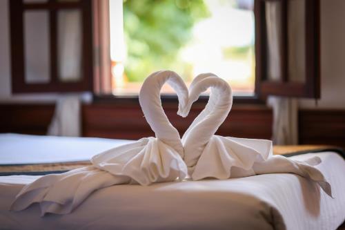 two swans forming a heart on a bed at Villa Chitdara in Luang Prabang