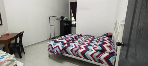a bed with a colorful comforter in a room at Homestay Indera kayangan in Kangar