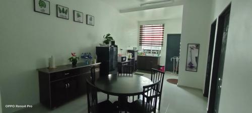 a kitchen with a table and chairs and a refrigerator at Homestay Indera kayangan in Kangar