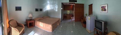 Baan Boonsang Pranburi บ้านบุญสร้าง ปราณ في Ban Nong Ban Kao: غرفة نوم بسرير وتلفزيون في غرفة