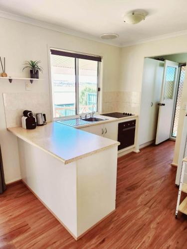 a kitchen with white counters and a counter top at Yaringa Cottage, ultimate entertainer! in Encounter Bay