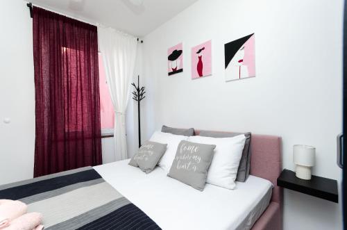 a white bedroom with a bed and a window at Apartment Mare in Vrsar