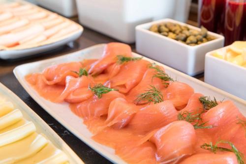 a plate of fish on a table with cheese at Budapest Marriott Hotel in Budapest