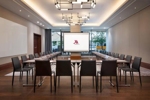 a conference room with a large table and chairs with a screen at Budapest Marriott Hotel in Budapest