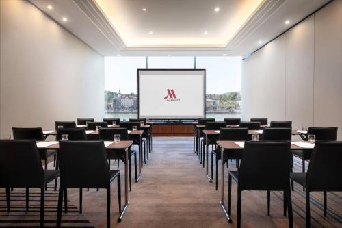 a conference room with tables and chairs and a screen at Budapest Marriott Hotel in Budapest