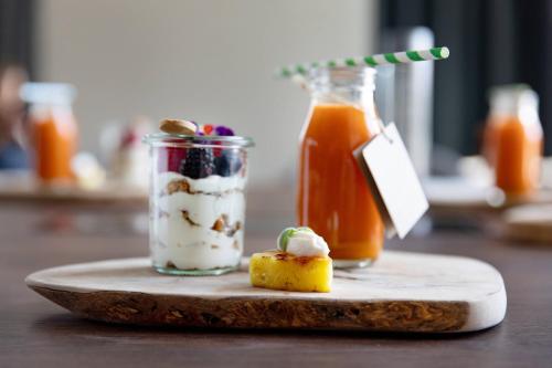 a plate with two jars of yogurt and a drink at Budapest Marriott Hotel in Budapest