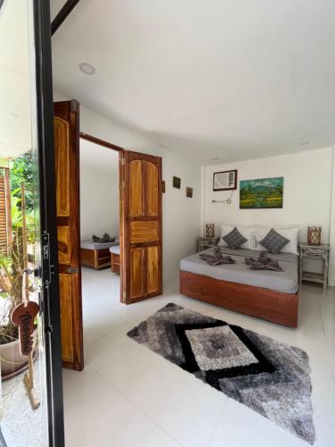 a bedroom with a bed and a large window at Hutch Lodging House in El Nido