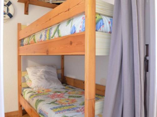 a bunk bed with a wooden bunk bed frame with a bunk bedsheet at Saint Pierre la Mer, Appt 2 pièces, cabine, 6 couchages, près plage, animaux OK - FR-1-229D-249 in Saint Pierre La Mer