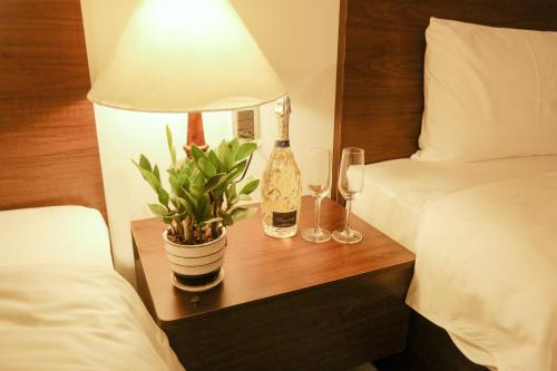 a bedroom with a table with a bottle of wine and a plant at AUI Hotel 95 Nguyễn Trãi in Ðoan Xá