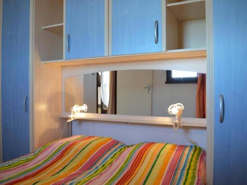 - une chambre avec un miroir et un oreiller rayé dans l'établissement Appt cosy 4 pers avec piscine, tennis, parking - plage à 850m - FR-1-229D-16, à Saint Pierre La Mer