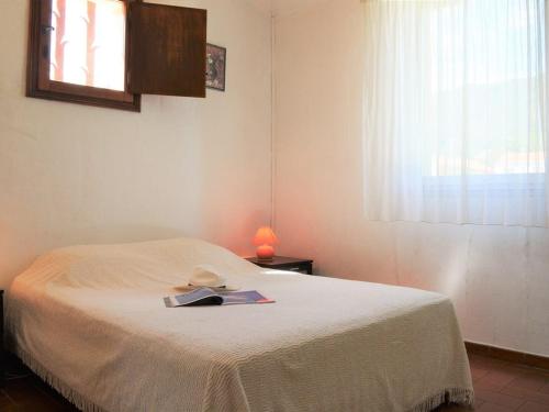 - une chambre avec un lit et un livre dans l'établissement Appartement 2 pièces avec mezzanine et parking, proche plage - Le Lavandou - FR-1-251-205, au Lavandou