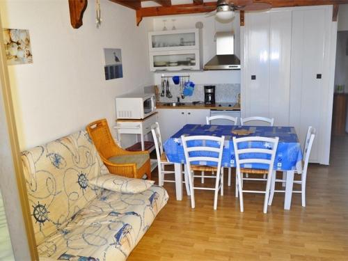 een woonkamer met een tafel en stoelen en een bank bij Appartement Port Barcarès, 3 pièces, 6 personnes - FR-1-431-15 in Le Barcarès