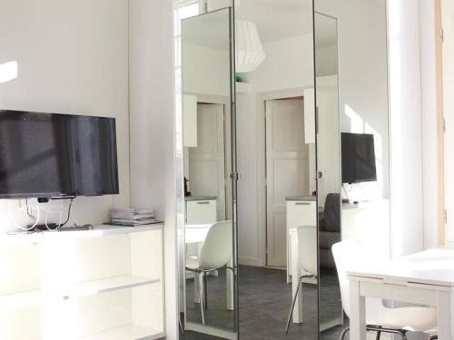 - un salon avec une télévision et un miroir dans l'établissement Charmant Studio Rénové, Idéalement Situé à La Baule, Proche Plage et Commodités - FR-1-245-86, à La Baule