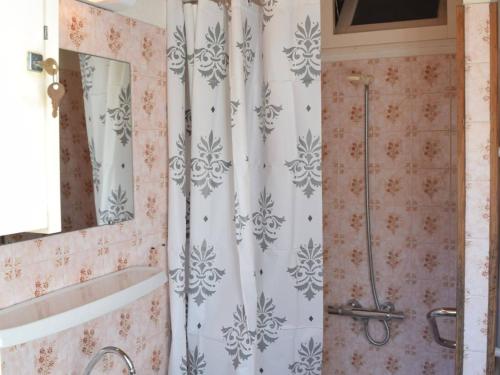 La salle de bains est pourvue d'un rideau de douche et d'une baignoire. dans l'établissement Maison de plain pied, 300m de la plage, accès mer privatif, 2 chambres, terrasse et parking - FR-1-224B-33, à Noirmoutier-en-l'lle