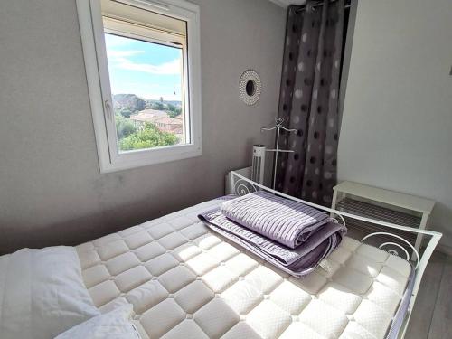 une chambre avec un lit blanc avec une fenêtre dans l'établissement T2 avec Wi-Fi, Parking Privé, Piscine et Tennis à 200m des Plages et Commerces - FR-1-316-259, à Six-Fours-les-Plages