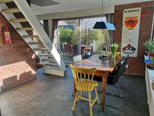 - une salle à manger avec une table et des chaises en bois dans l'établissement Holiday home Sunset, à Noordwijkerhout