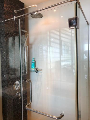 W łazience znajduje się prysznic ze szklanymi drzwiami. w obiekcie Phupha Rayong by gift w mieście Klaeng