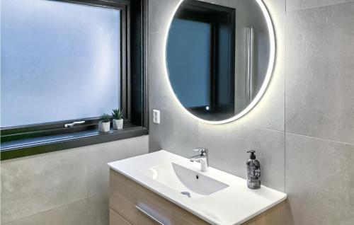a bathroom with a sink and a mirror at Amazing Home In Hebnes With House Sea View in Hebnes