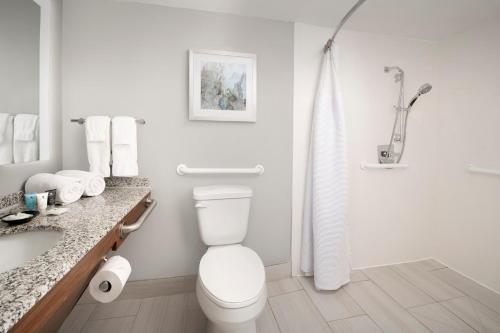 a white bathroom with a toilet and a shower at Crowne Plaza San Antonio Airport by IHG in San Antonio