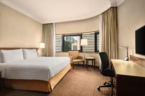 a hotel room with a bed and a desk and a computer at Holiday Inn Singapore Atrium by IHG in Singapore
